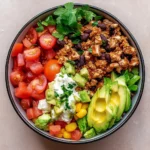Healthy turkey taco bowl with fresh ingredients and garnishes